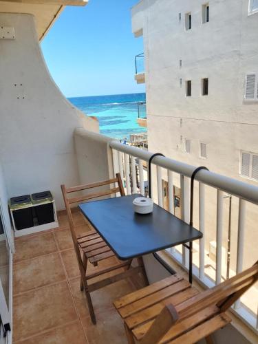 une table et des chaises sur un balcon avec l'océan dans l'établissement Apartamento Vista ET88PL, à Es Pujols