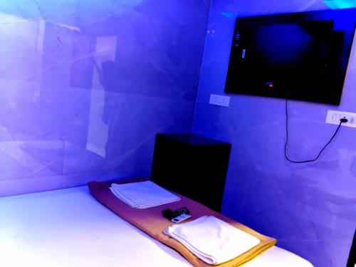 a room with a bed and a tv on a wall at Hotel Aashray Residency Lodging And Boarding in Jāmb