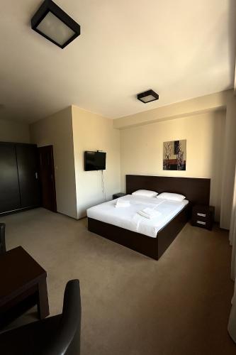 a bedroom with a bed and a flat screen tv at Przystanek Słupno in Słupno
