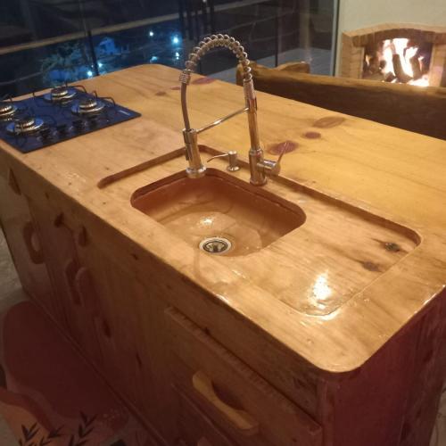 a wooden counter with a sink and a stove at Cabana com Hydro, Recanto das Trutas, SC in Bocaina do Sul