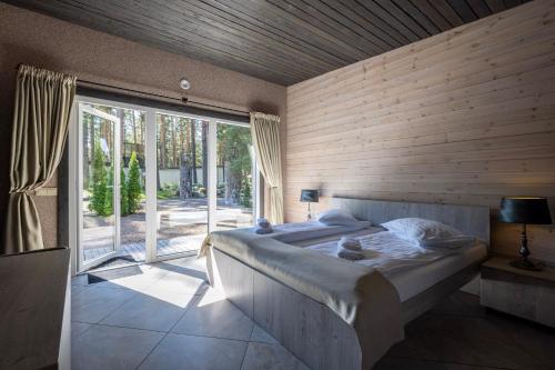 a bedroom with a large bed and a large window at Villa Valery - pajūrio dvasia dvelkianti oazė in Kupriai