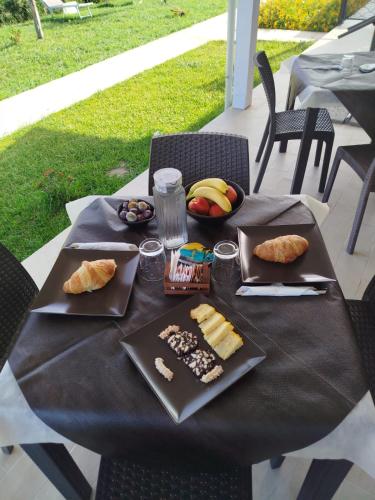 a black table with plates of food on it at Galaxy Rooms Tropea in Drapia
