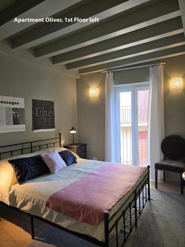 a bedroom with a bed and a chair and a window at Casa Montebello in Bellagio
