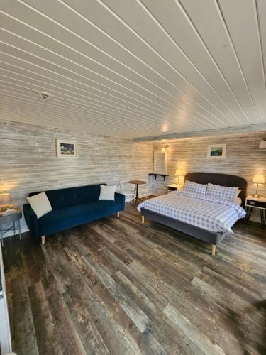 a bedroom with two beds and a blue couch at Loughview chalet in Whitehouse Lower