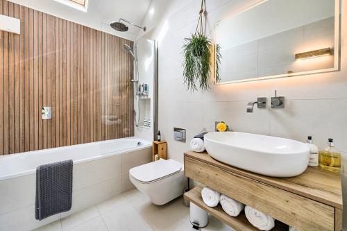 ein Badezimmer mit Waschbecken, Badewanne und Toilette in der Unterkunft Weston Cottage 4 in Send
