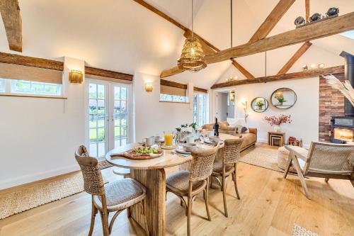 a dining room and living room with a table and chairs at Weston Cottage 4 in Send