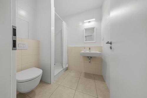 a white bathroom with a toilet and a sink at Air conditioned 1 room apartment with parking, new building, Ružinov in Trnávka