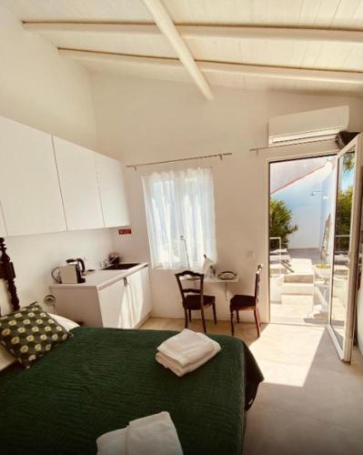 a bedroom with a green bed and a kitchen with a balcony at Alma da Vida Ferragudo in Ferragudo