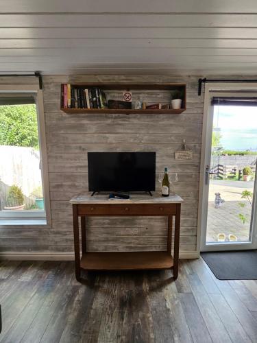 a room with a desk with a tv and a window at Loughview chalet in Whitehouse Lower
