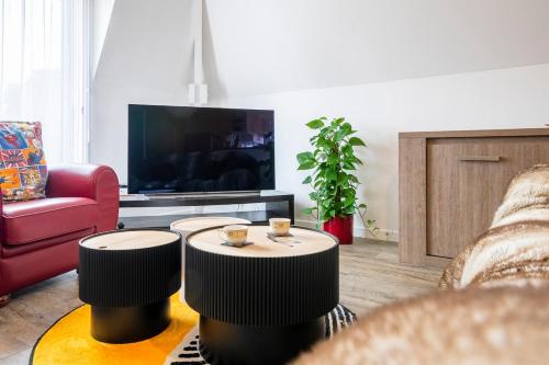 a living room with two tables in front of a tv at Beautiful apartment, shops within walking distance, Vannes 5 min in Plescop