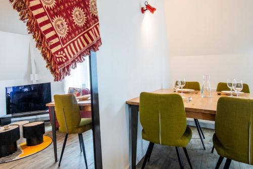 a dining room with a wooden table and green chairs at Beautiful apartment, shops within walking distance, Vannes 5 min in Plescop