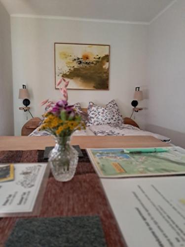 a living room with a table with a vase of flowers at Haus Franziska in Hallstatt