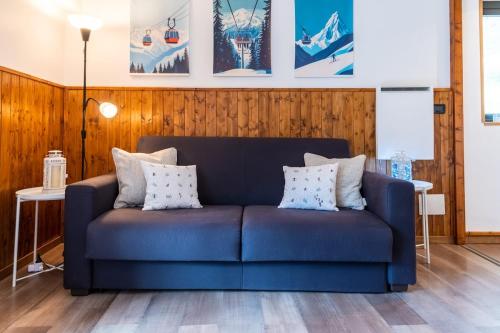 a blue couch in a living room with wooden walls at MCX Vacation Rental - Belle Vue Les Grandes Murailles, Pet Friendly Apartment just 300 meters from the ski lifts! in Breuil-Cervinia