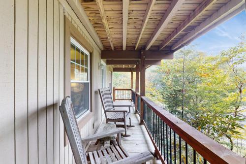 a porch with two chairs on a house at Tree Top Cabin in Beech Mountain