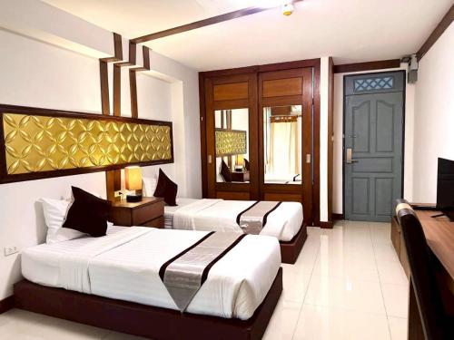 een slaapkamer met 2 bedden en een blauwe deur bij ลีลาวดี รามอินทรา - Leelawadee Resotel Raminthra 23 in Bangkok