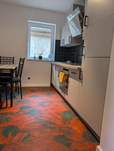 a kitchen with a floor covered in colorful carpet at Brick House in Frohburg