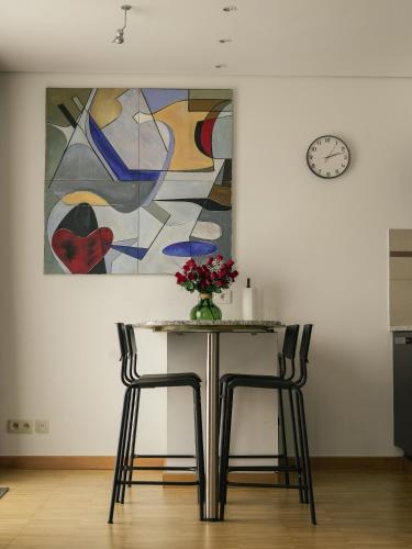 una mesa con dos sillas y un cuadro en la pared en Elios Living Studio Mettewie, en Bruselas