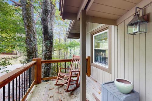 a porch with two rocking chairs and a window at Tree Top Cabin in Beech Mountain