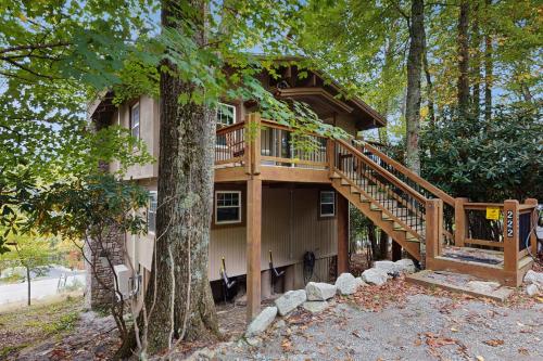 a tree house with a deck in the woods at Tree Top Cabin in Beech Mountain