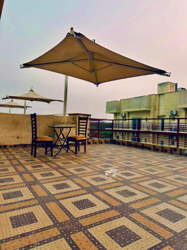 a patio with a table and an umbrella on a roof at Hotel Meena Laxmi Inn 