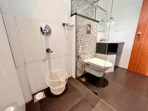 a small bathroom with a toilet and a shower at Hotel Meena Laxmi Inn 