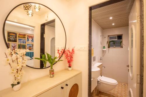 a bathroom with a mirror and a toilet at Casa Leo by Leo Homes 2BHK Flat near Anjuna Beach in Anjuna