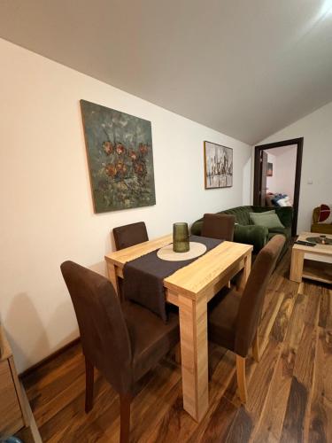 a dining room with a table and chairs and a couch at Gintas Comfort in Podgorica