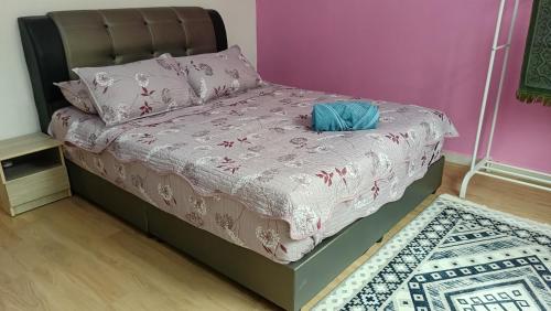 a bed in a room with a pink wall at Homestay Annur Barakah in Kampung Raja