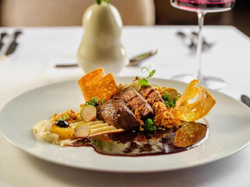 a plate of food with meat and vegetables on a table at Palazzo President in Split
