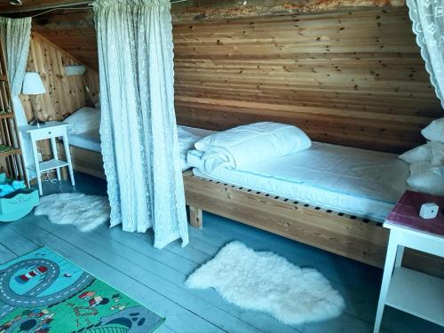 a bedroom with a bed in a log cabin at Charming holiday home with views of the landscape and close to Lake Vättern in Hjo