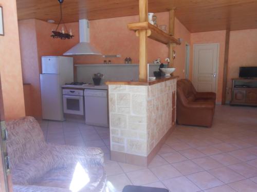 eine Küche mit Herd und Theke in einem Raum in der Unterkunft Chez Maurice et Sylvie in Laveissière