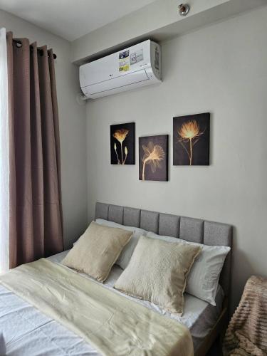 a bed in a bedroom with three pictures on the wall at Cozy Studio with Balcony and Pool Near Airport and Beaches in Suba