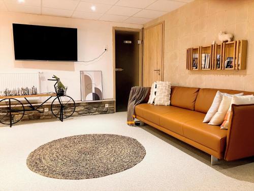 a living room with a couch and a flat screen tv at Terrier Ovifat - logement familial Nature et Sauna in Ovifat