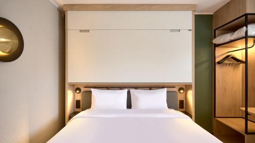 a bedroom with a large bed and a large window at Campanile Paris Ouest - Nanterre - La Défense in Nanterre