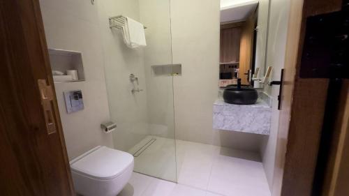 a bathroom with a shower and a toilet and a sink at منازل صوان للوحدات السكنية in Al Shafa
