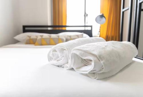 two beds with white blankets on top of them at Bright 1-Bedroom Loft in Converted Garage with Private Entrance in New Rochelle