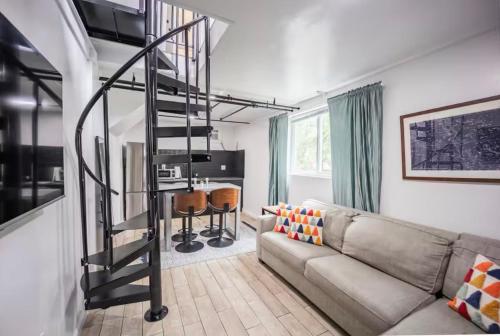 a living room with a couch and a spiral staircase at Bright 1-Bedroom Loft in Converted Garage with Private Entrance in New Rochelle