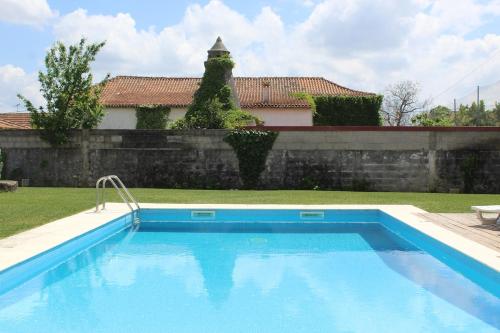 a swimming pool in a yard next to a wall at Casa do Caseiro, São Silvestre in São Silvestre