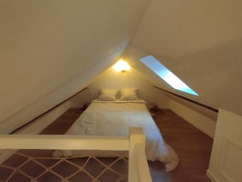 a bedroom with a bed in the attic at Duplex centre historique - Château et Loire - tout confort élégant et calme in Saumur