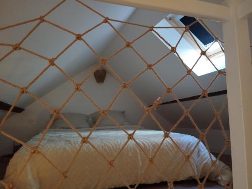 a bed in a triangular room with a window at Duplex centre historique - Château et Loire - tout confort élégant et calme in Saumur