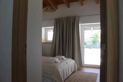 a bedroom with a bed and a sliding glass door at Casa do Caseiro, São Silvestre in São Silvestre
