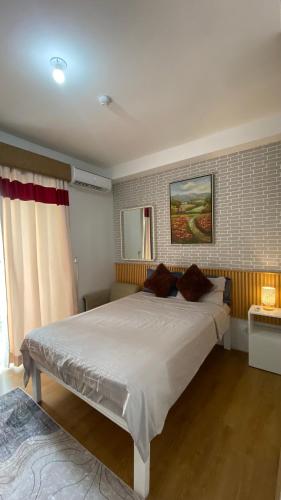 a bedroom with a large white bed with two pillows at Honey's Staycation in Davao City