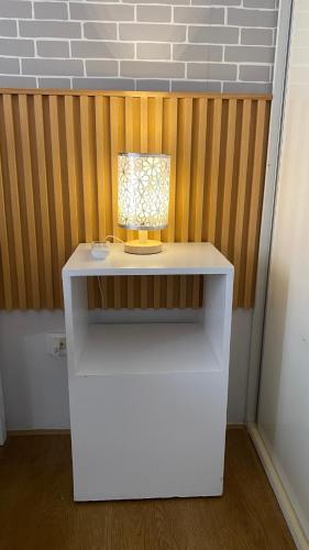a white table with a lamp on top of it at Honey's Staycation in Davao City