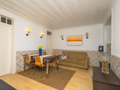 a living room with a table and a couch at Descubra Lisboa - Príncipe Real in Lisbon