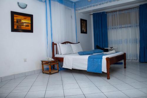 a bedroom with a bed and a table in it at Hotel Windsor-Mombasa in Mombasa