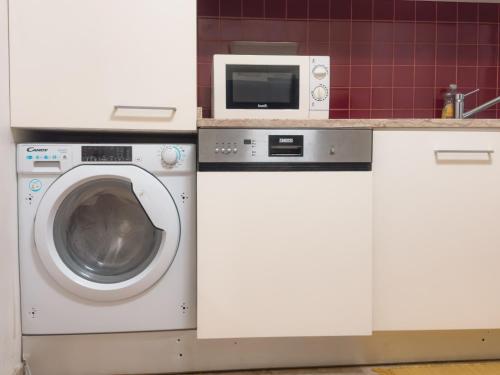 a kitchen with a washing machine and a microwave at Descubra Lisboa - Príncipe Real in Lisbon