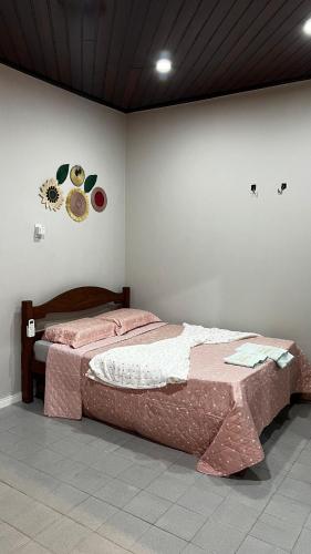 a bedroom with a bed with a flower on the wall at Loft Hipolito in Belém