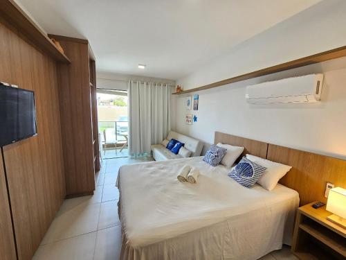 a hotel room with a bed and a living room at Açores Praia de Tamandaré - À Beira-Mar in Praia dos Carneiros