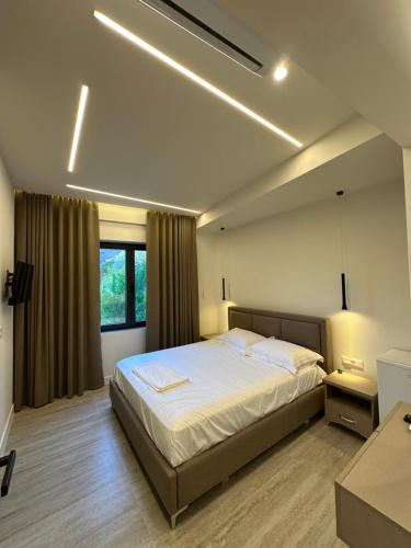 a bedroom with a large bed and a window at Hotel Gramozi in Kaninë
