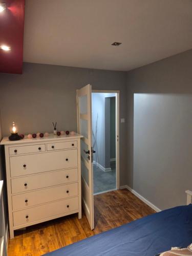 a bedroom with a bed and a dresser with a mirror at Apartament KARO in Zawiercie